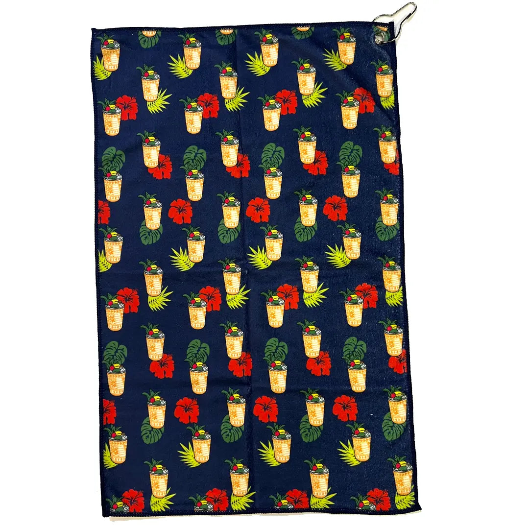 Towel with tropical pattern featuring drinks, flowers, and leaves on a blue background