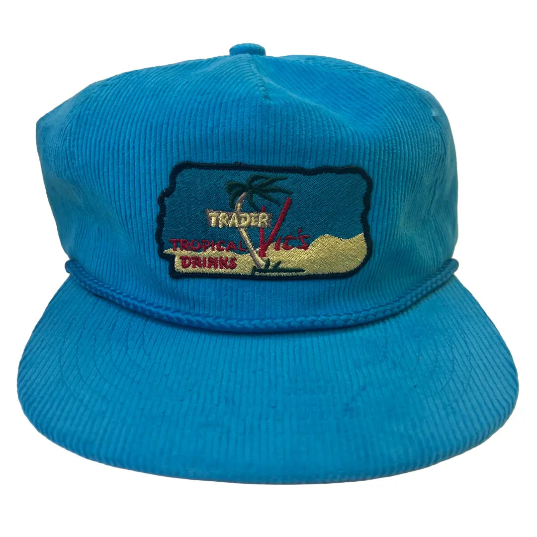 Blue corduroy cap with embroidered design on a white background