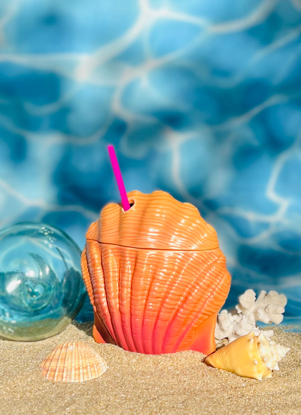 Seashell mug on sand.