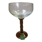 Decorative glass with a tiki-themed stem on a white background