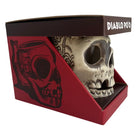 A skull-shaped ceramic mug displayed inside its red and black branded retail box. The box lid reads 'DIABLO POO'.
