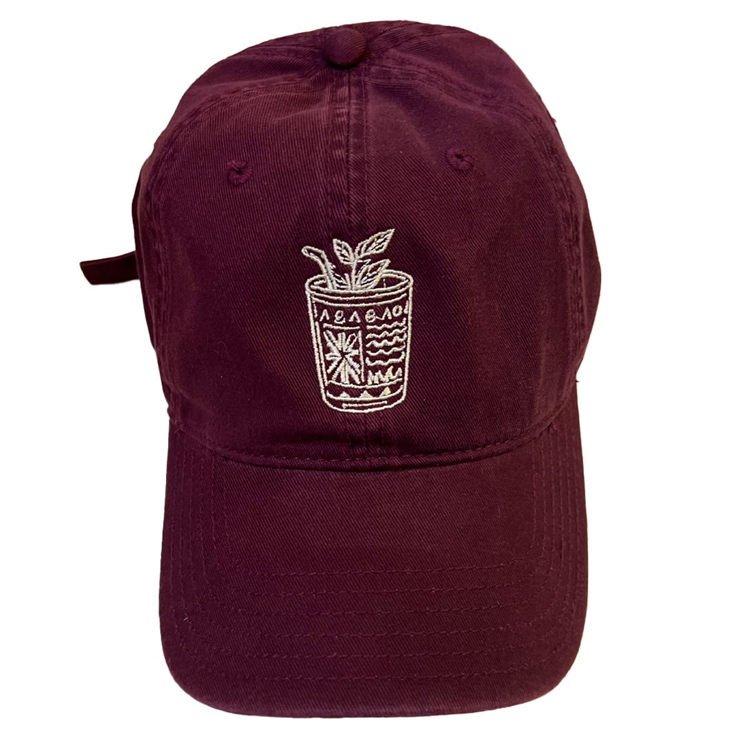 Maroon cap with white embroidered design on a white background