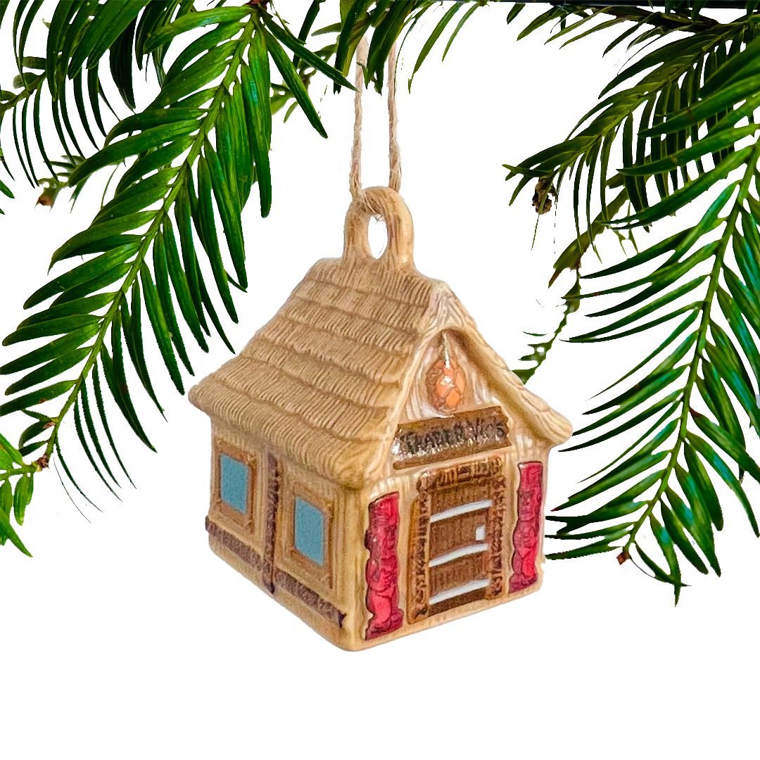 Decorative house ornament hanging on a green branch