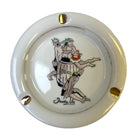 A round ceramic ashtray with a glossy cream-white glaze, featuring a hand-painted illustration of Trader Vic's vintage cocktail menu scene.