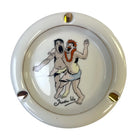 A round ceramic ashtray with a glossy cream-white glaze, featuring a hand-painted illustration of Trader Vic's vintage cocktail menu scene.